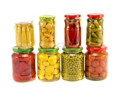 在白色隔离的玻璃罐中收集各种罐装蔬菜