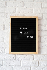 白砖墙上黑色字母板上的文本黑色星期五销售