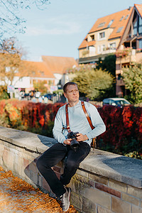 坐在老欧洲城市和拿着照相机的人。