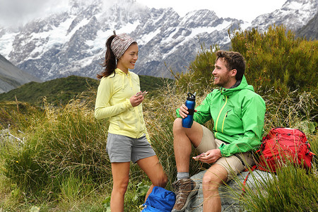 野营生活方式的年轻人在新西兰山间小径上徒步旅行时在户外吃午餐。