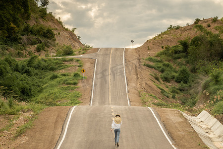 人曲线摄影照片_女人独自在美丽空旷的乡村曲线，柏油路。