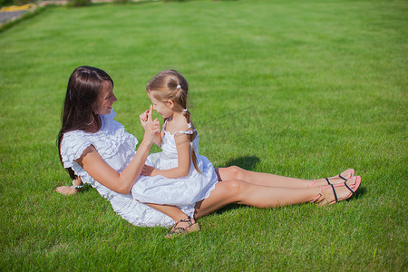 小女孩和她年轻的妈妈在院子里玩得很开心