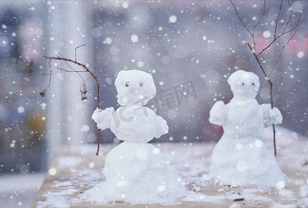 小雪人摄影照片_两个可爱的小雪人，用树枝代替手