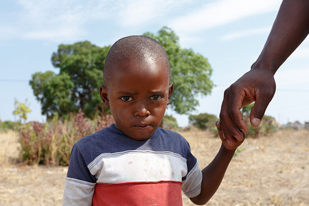 纳米比亚小男孩的肖像与父亲的手