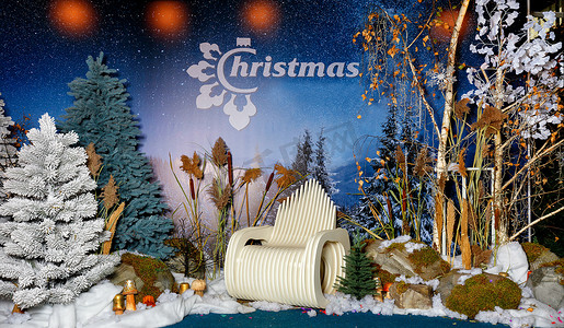 圣诞树木摄影照片_新年圣诞组合物，包括人造树、雪、巨石和一把原始木椅。