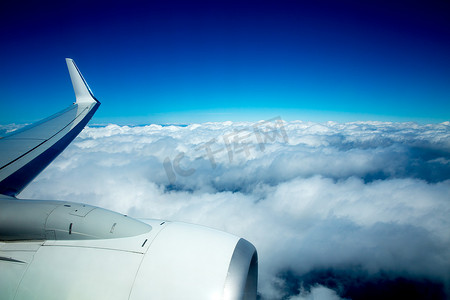 飞机机翼飞过蓝天蓬松的云彩
