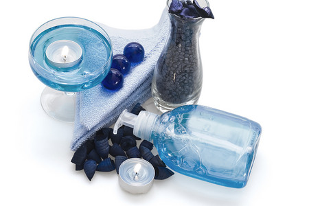 口腔护理液摄影照片_身体护理液、蜡烛和蓝色小卵石