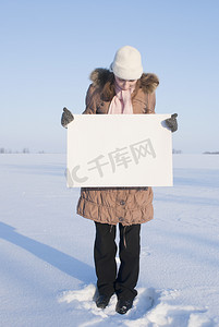 在冬天雪地里拿着白色海报的女孩