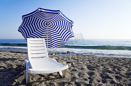 带伞摄影照片_带伞的躺椅独自矗立在蔚蓝的海边