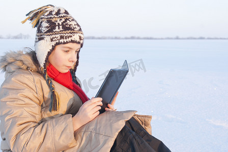 冬时在户外看电子书的少女
