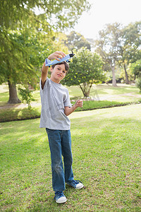 男孩在公园玩玩具飞机