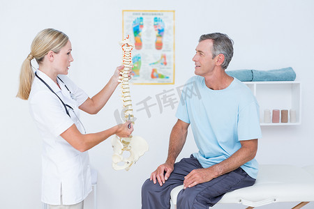 位移传感器摄影照片_医生向她的病人展示解剖脊柱