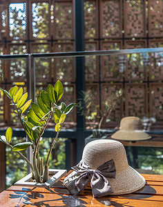 桑给巴尔宝石树附近的夏季帽子，放在木制休闲椅上，供假日背景使用。