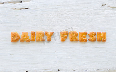 木背景上的 Word DAIRY FRESH 字母饼干