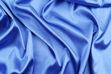 布匹丝绸摄影照片_蓝色丝绸，有一些柔软的褶皱和高光。