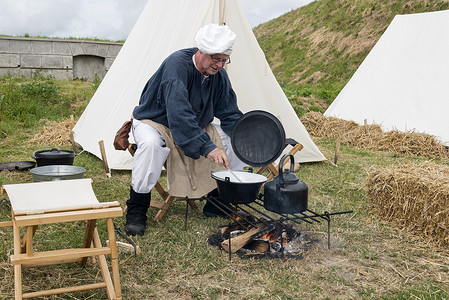 在做饭的人摄影照片_在篝火上做饭的人