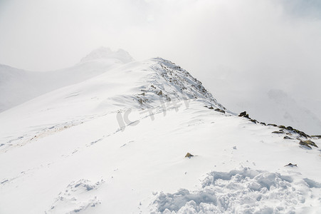 多云的雾天，滑雪胜地，冬季高加索山景，框架中有一座岩石峰