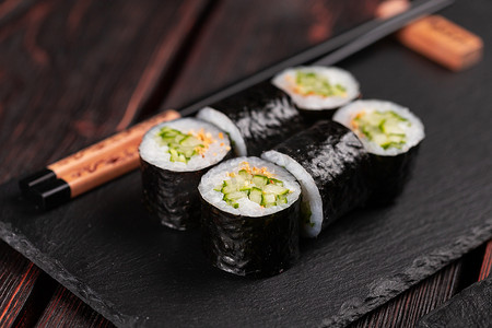 Maki 寿司卷黄瓜和芝麻用筷子特写。