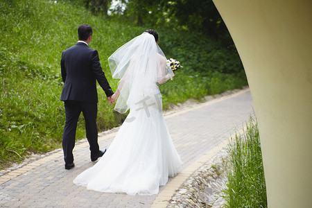 新娘的摄影照片_新郎新娘在夏日手牵着手向前走