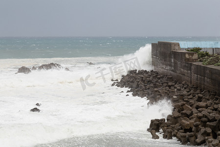 在台风期间的风雨如磐的海，在障碍墙壁上碰撞的波浪