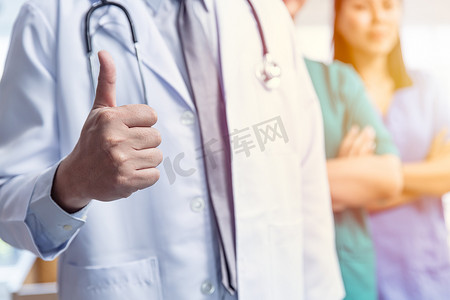 医生医疗团队手竖起大拇指表示良好护理，证实了病毒保护服务的医疗保健理念。