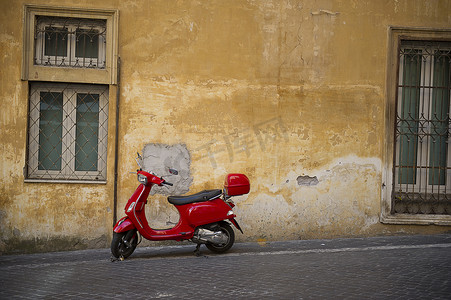 vespa摄影照片_城市街道上亮红色的 Vespa 滑板车