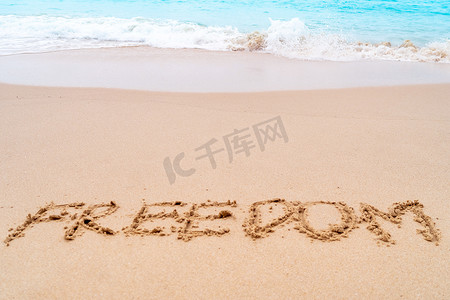 自由词手绘在沙滩上的夏日海滩上。