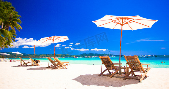 在异乎寻常的热带白色沙滩的海滩睡椅