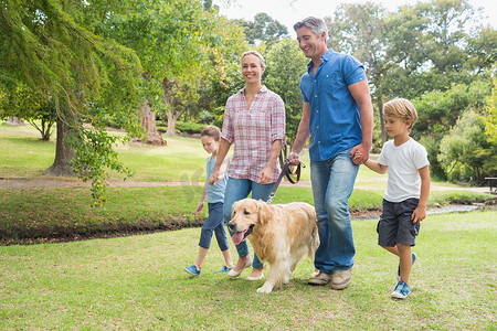 幸福的家庭和他们的狗在公园里