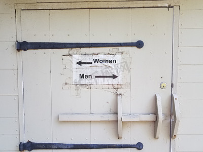 带男女洗手间标志和箭头的木门