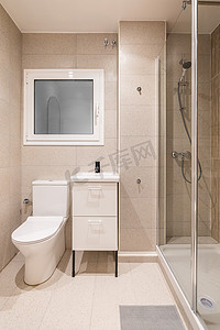 家居洗手间摄影照片_带透明玻璃墙的小淋浴区的浴室。