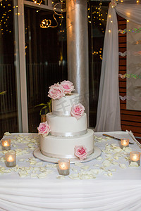 三层冰婚礼蛋糕与粉红玫瑰