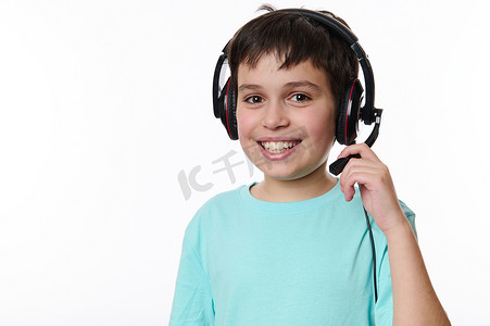 聪明的少年戴着耳机，准备上网课，微笑着可爱地看着镜头，被白色隔离