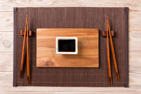 空的长方形木板，木背景上有筷子，用于寿司和酱油。
