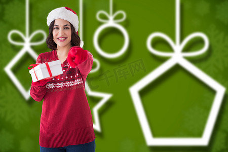 戴着圣诞帽的快乐黑发女郎提供礼物的合成图像