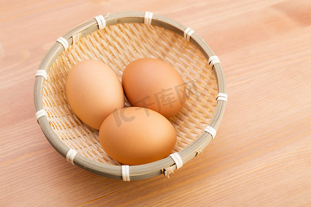 木制背景下篮子里的鸡蛋