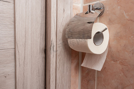 一卷卫生纸挂在厕所的支架上