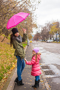 雨天和妈妈打伞散步的小女孩