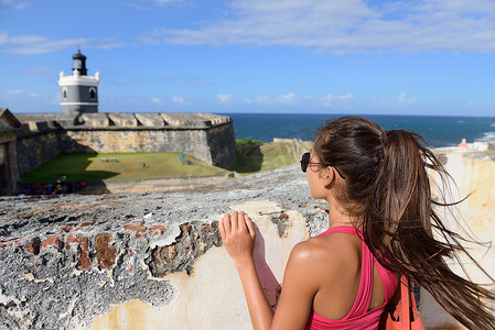 卡斯蒂略摄影照片_波多黎各在圣胡安旅游的女游客，俯视着美国波多黎各老圣胡安市的著名景点卡斯蒂略圣费利佩德尔莫罗堡。