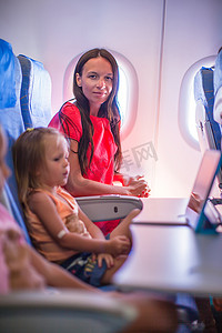 年轻的母亲和她的小女儿在飞机上
