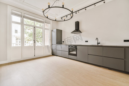 灰色橱柜摄影照片_带灰色橱柜和浅色木地板的厨房