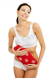 可爱的内裤摄影照片_拿着一个红色枕头的可爱的妇女。