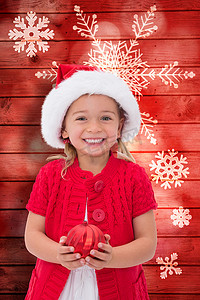 雪花圣诞帽摄影照片_戴着圣诞帽拿着小玩意的可爱小女孩的合成图像