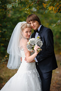 胸花新娘摄影照片_幸福的新娘和新郎在公园举行的婚礼上