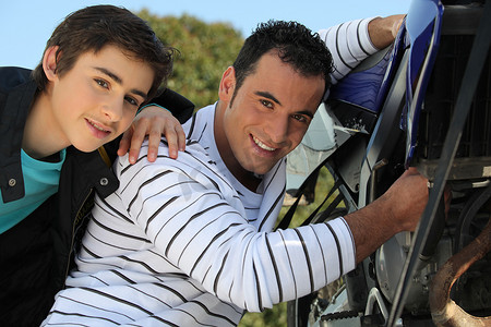 摩托男孩摄影照片_父亲和儿子在摩托车上工作
