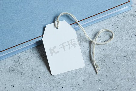 蓝皮书和灰色背景上带有白卡的矩形白色礼品标签模型