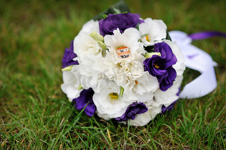 新娘捧花摄影照片_躺在绿草地上的新娘捧花