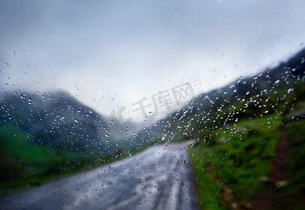 雨天、汽车和雨中的道路透过窗户抽象图像
