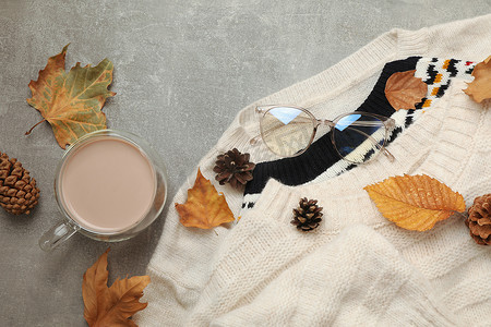 灰色背景上的毛衣和咖啡秋装概念