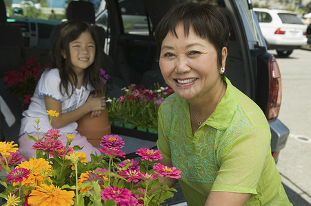 快乐的祖母在车里装各种花的肖像